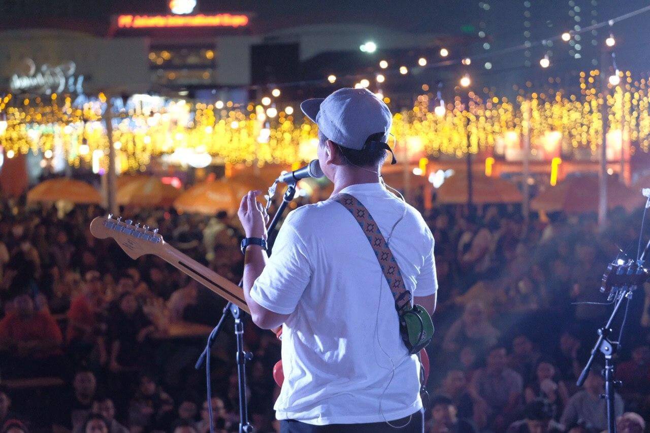 Tampak belakang Cholil vokalis Efek Rumah Kaca bernyanyi Bersama penonton